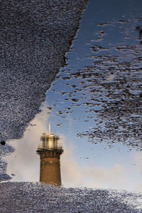 Reflection of building on puddle at beach