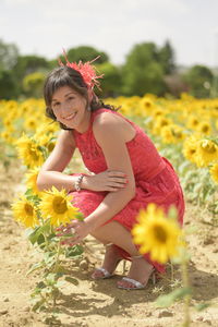 Portrait of smiling woman crouching on field