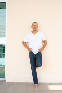 Portrait of young man standing against wall
