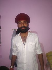 Portrait of young man standing against wall