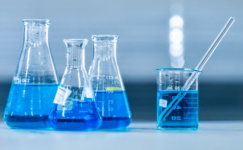 Close-up of glass container against blue background