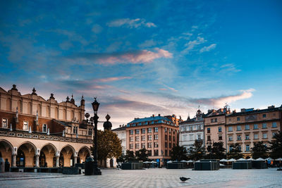 Buildings in town against cloudy sky