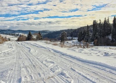 Snow covered landscape against sky