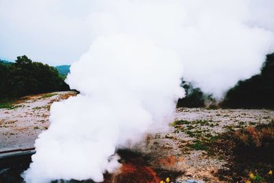 Smoke emitting from mountain against sky