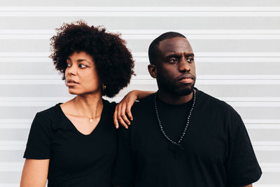 Black cool couple posing over white background looking at camera