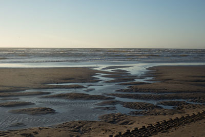 View of calm beach against clear sky