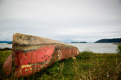 Abandoned upside down boat on lakeshore