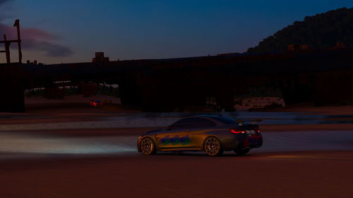 Cars on road against sky in city at dusk