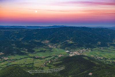 Scenic view of agricultural landscape against sky during sunset