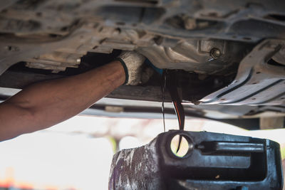 Cropped hand of mechanic repairing car