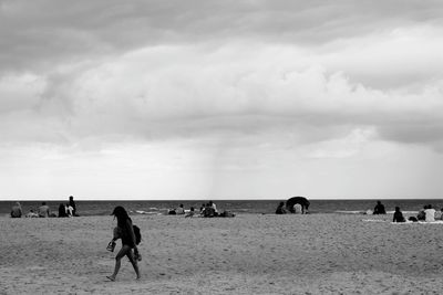 People at beach against sky