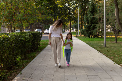 Mother and daughter strolling in park on a sunny day
