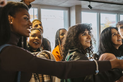 Smiling multiracial students checking test results together at university