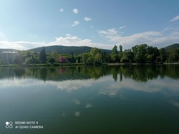 Scenic view of lake by trees against sky