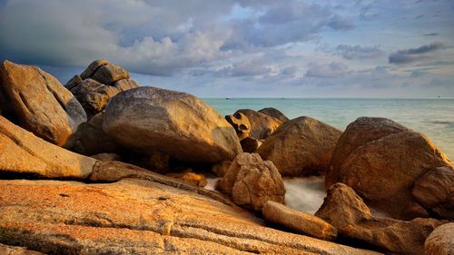 Rocks by sea against sky