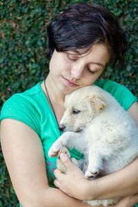 Close-up of teenage girl embracing puppy