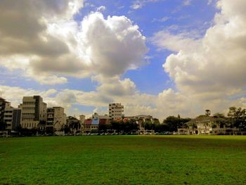 View of grassy field against cloudy sky