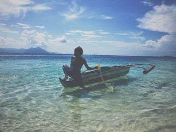 Man in boat on sea against sky