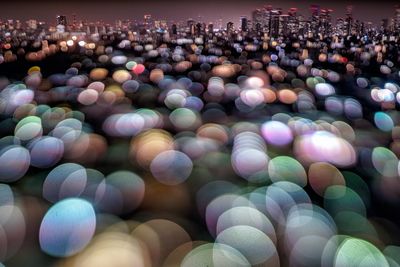 Defocused image of illuminated lights in city at night