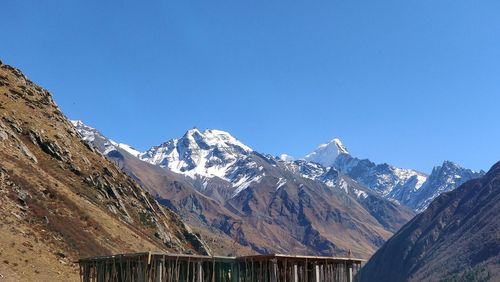 Scenic view of snowcapped mountains against clear blue sky