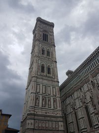 Low angle view of clock tower against cloudy sky