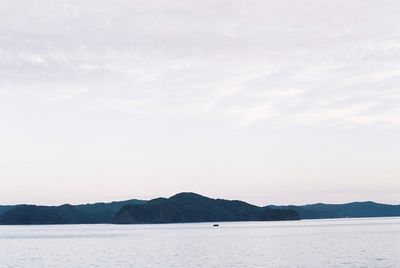 Scenic view of sea and mountains against sky