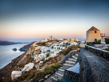 High angle view of buildings by sea against sky during sunset