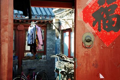 Bicycles parked by house seen through gate