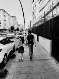 Rear view of women walking on street in city