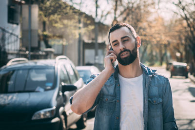 Man talking on mobile phone in city