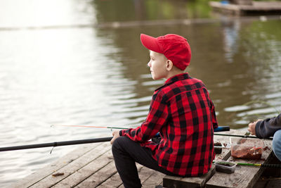 Rear view of man sitting in lake