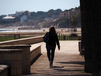 Rear view of woman walking on street