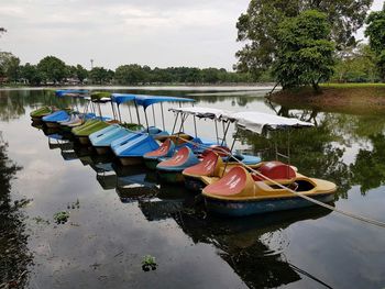 Boats moored in lake against sky