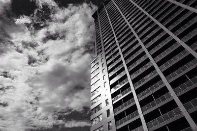 Low angle view of skyscrapers against cloudy sky