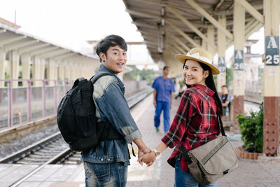 Full length of a smiling young couple standing outdoors