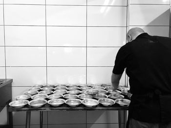 Rear view of man preparing food in kitchen