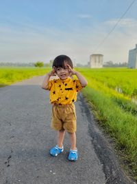 Portrait of boy standing on road