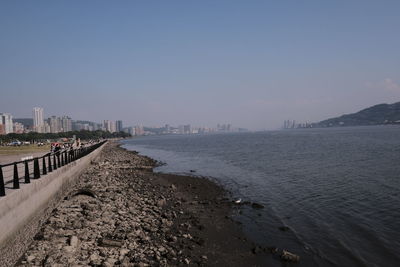 Scenic view of sea and buildings against clear sky