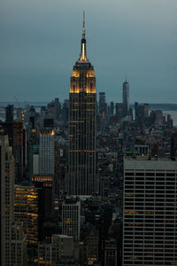 Modern buildings in city against sky at dusk