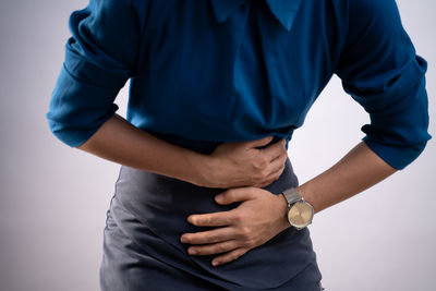 Midsection of man standing against white background