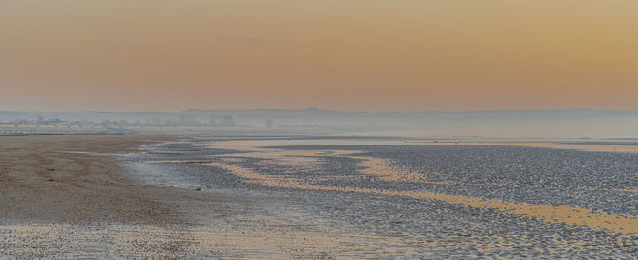 Scenic view of beach against sky during sunrise