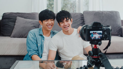 Gay couple making video while sitting at home