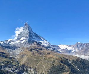 Scenic view of snowcapped mountains against clear sky