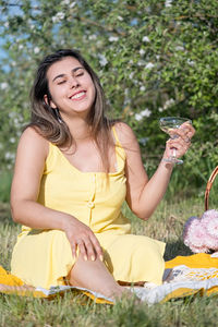 Portrait of young woman sitting on field