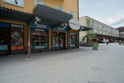 Information sign on store in city against sky