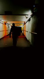 Rear view of a silhouette woman standing in corridor