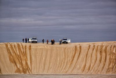 Panoramic view of people on desert against sky