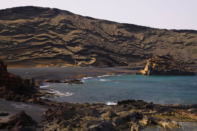 Scenic view of sea and mountains against sky