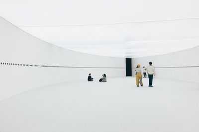 People walking on white wall