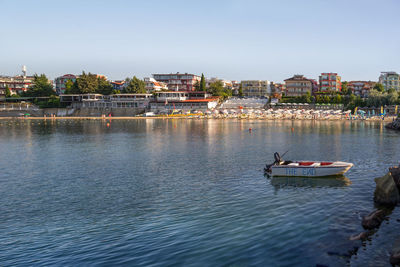 Scenic view of river by buildings against clear sky